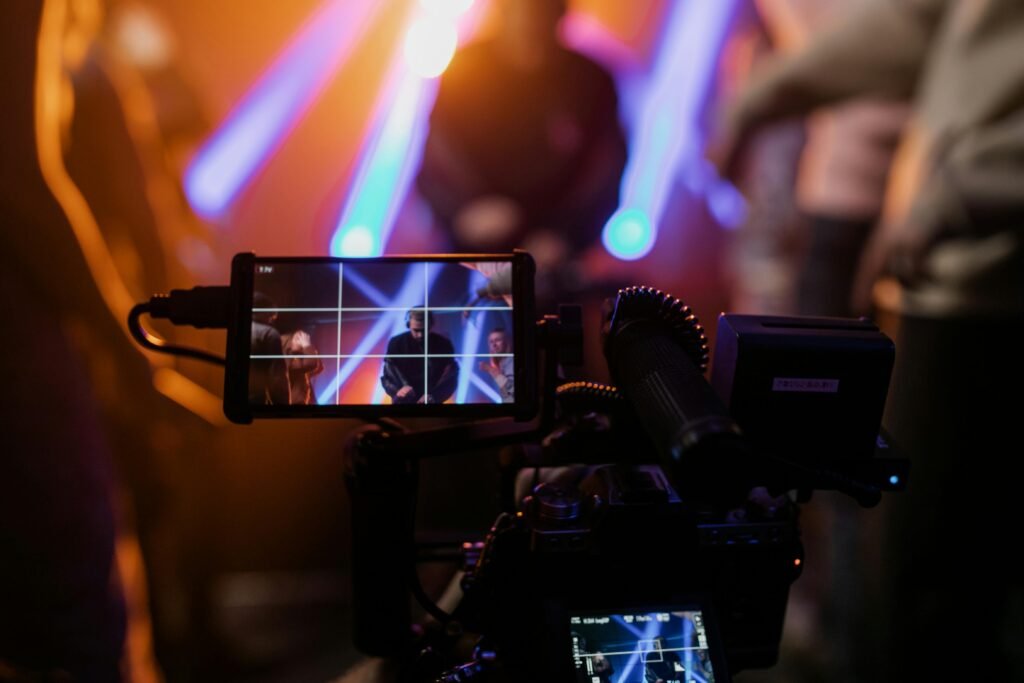 Capturing a vibrant live concert scene with dynamic lighting using professional video equipment.